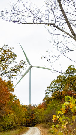 Wind turbine in the autumn forest. Windmill for electric power production.の写真素材