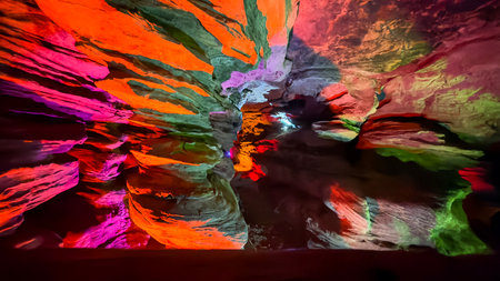 Vibrantly Lit Cave with Reflections of Multicolored Lights on Stone Wallsの写真素材