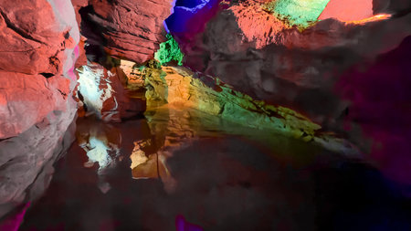 Colorful Illuminated Cave with Reflections on Underground Waterの写真素材