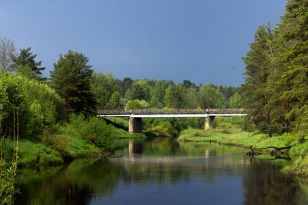 concrete bridge over the river among the forestの写真素材