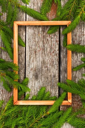 Christmas background for greeting card. wooden frame and Fir branches on wooden background.の写真素材