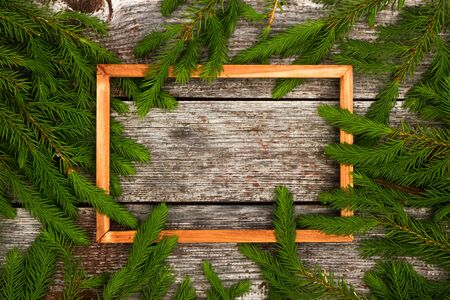 Christmas background for greeting card. wooden frame and Fir branches on wooden background.の写真素材