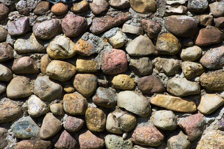 masonry with round stones on cementの写真素材
