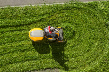 Russia Peterhof 14.09.2020.man in a work uniform mows lawn with a Garden Riderのeditorial素材