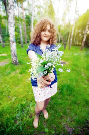 Beautiful girl with bouquet of lilly of valley and  Forget me notの写真素材