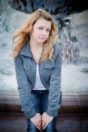 Beautiful young woman portrait with fountain behindの写真素材