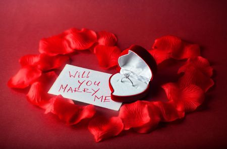 Card with ring in box on red backgroundの写真素材