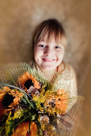 Girl portrait  with bouquet of sunflower on yellow backgroundの写真素材