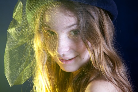 Beautiful girl portrait with retro hat in yellow lightの写真素材