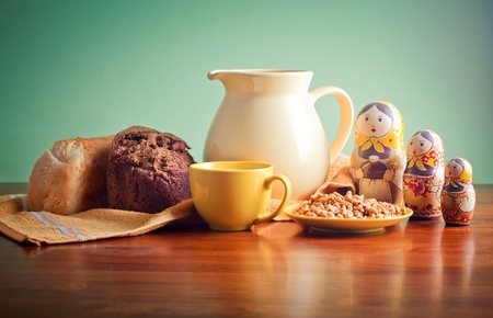 Pitcher of milk, bread, and wheat on wooden tableの写真素材