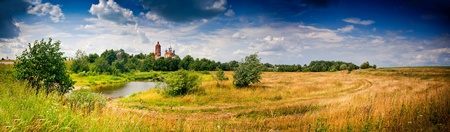 Summer panoramic landscape with river and churchの写真素材