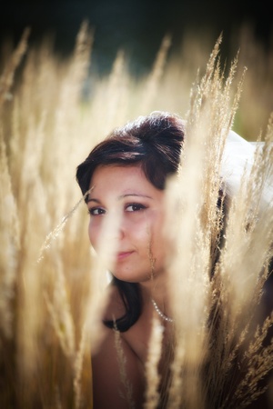Beautiful bride posing in autumn fieldの写真素材