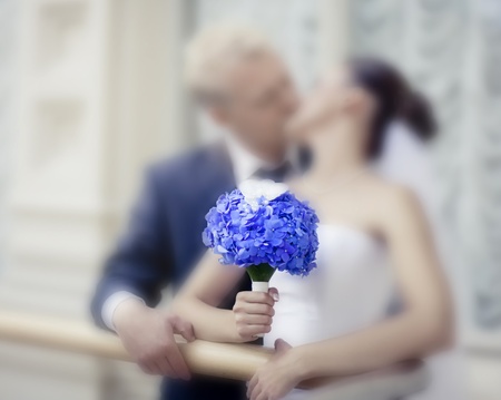 Kissing newlyweds with the Hydrangea bouquet. Soft focus on bouquetの写真素材