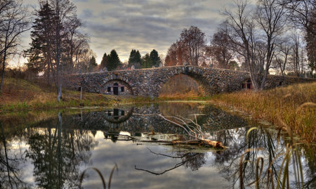Autumn landscape with arched boulder bridge 