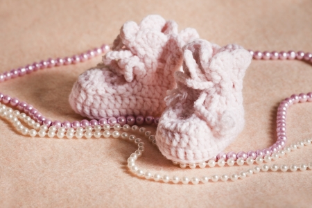 Pink baby shoes on peach backgroundの写真素材