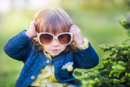Happy smiling little girl in big sun glassesの写真素材