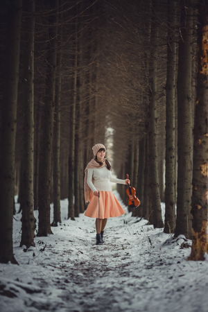 Teenage girl portrait with violin in winter parkの写真素材
