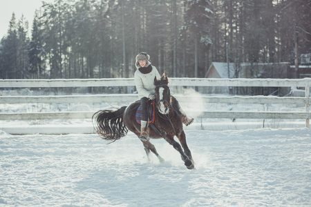 Winter teenage girl jump horse ride jumpingの写真素材