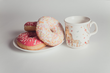 Easter eggs with donuts on the white table in daylightの写真素材