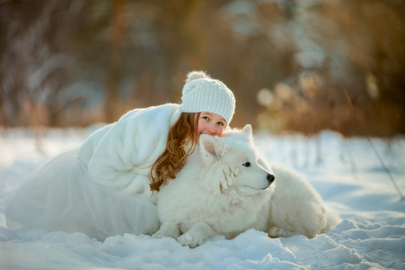 Winter beautiful  girl portrait with samoyed dog in sunny parkの写真素材