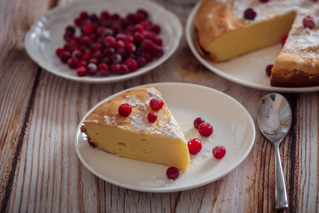 Breakfast with Cheesecake with cranberries and sugar, green tea and lemon on wooden tableの写真素材
