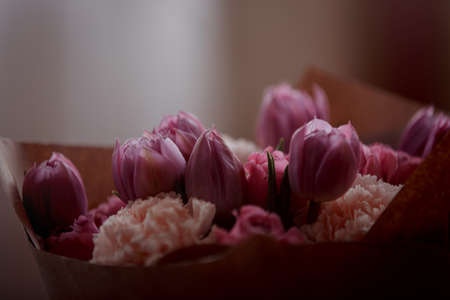 Bouquet of beautiful flowers with purple peony roses, carnations and tulips, in the craft paperの写真素材