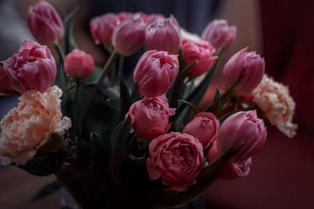 Bouquet of beautiful flowers with purple peony roses, carnations and tulips, in the craft paperの写真素材