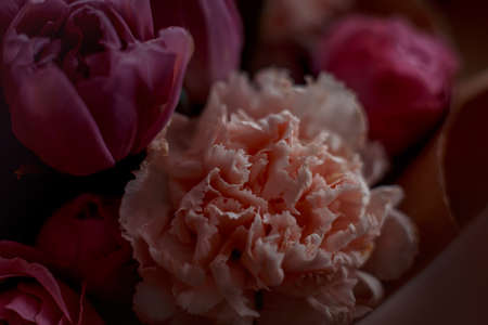 Bouquet of beautiful flowers with purple peony roses, carnations and tulips, in the craft paperの写真素材
