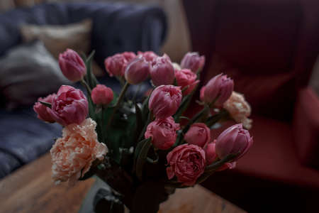Bouquet of beautiful flowers with purple peony roses, carnations and tulips, in the craft paperの写真素材