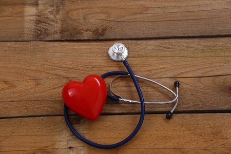A heart with a stethoscope, isolated on wooden backgroundの写真素材