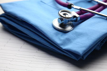 Doctor coat with stethoscope on the desk .の写真素材