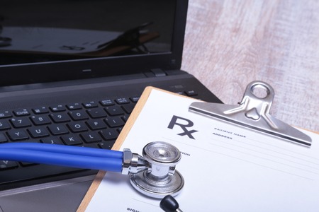 Prescription form with laptop computer and stethoscope.の写真素材
