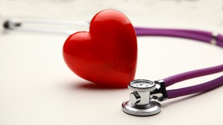 A heart with a stethoscope, isolated on wooden backgroundの写真素材