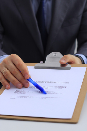 Business man signing a contract, sitting on the deskの写真素材
