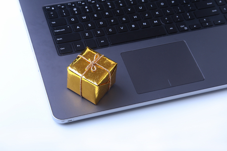 Laptop and christmas gifts box on white deskの写真素材