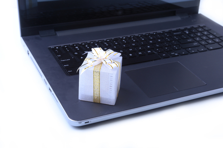 Laptop and christmas gifts box on white desk .の写真素材