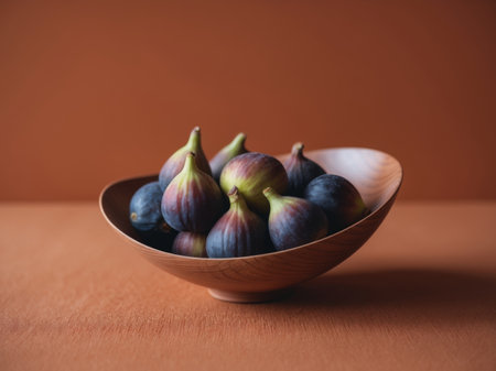 AI Generated. Fresh ripe figs in a wooden bowl on an orange backgroundの素材