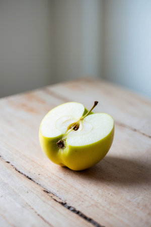 AI Generated. Yellow apple cut in half on wooden surfaceの素材