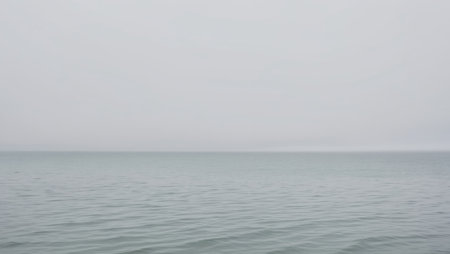 AI Generated. Calm overcast day at the tranquil sea with gentle ripples stretching to the horizonの素材