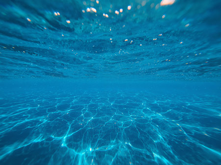 This image captures the beauty of underwater light, showcasing sunbeams and delicate ripples creating a serene atmosphere. Perfect for relaxation and escapism.の素材