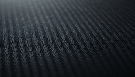 A dark, textured surface with a distinct woven pattern, featuring linear elements and a soft depth of field subtle lighting adds contrast and visual interest.の素材