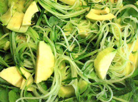 Raw vegan food as background. Salad of greens, fresh vegetables, avocado cucumber arugula, spinach, close-up.の写真素材