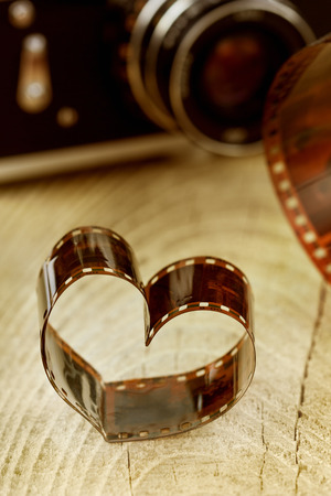 heart shaped made from retro film negative on wooden board with bokeh from vintage camera, toning, photography creative conceptの写真素材