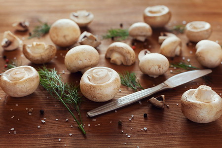 Cultured mushrooms champignons on wooden rustic backgroundの写真素材