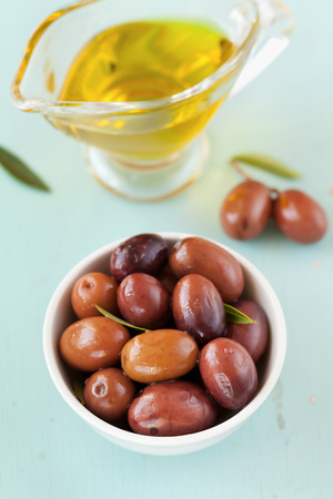 Fresh olives in white bowl on rustic wooden tableの写真素材