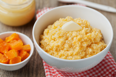 Millet porridge with baked pumpkin and butter in bowl on wooden table, baby foodの写真素材