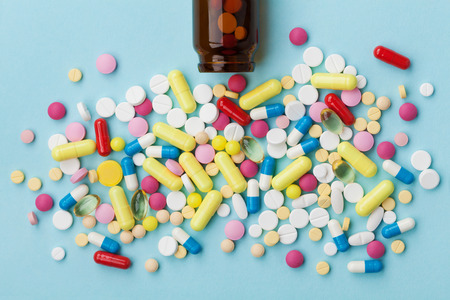 Colorful drug pills on blue background, pharmaceutical conceptの写真素材