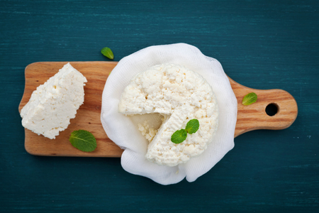 Homemade cottage cheese or curd on wooden board, rustic style, top viewの写真素材