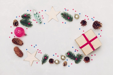 Christmas background of gift box, fir tree, conifer cone and holiday decorations on white table top view. Flat lay styling.の写真素材