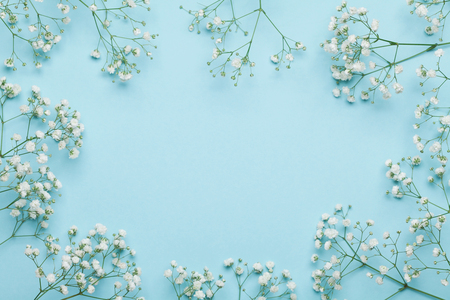 Wedding flower frame on blue background from above. Beautiful floral pattern. Flat lay style.の写真素材
